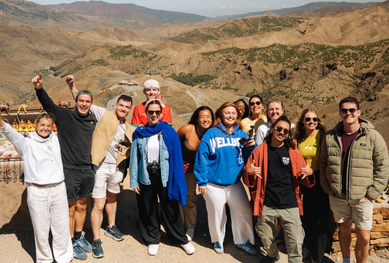 A group of young travellers pose with the amazing backdrop of the Moroccan Countryside
