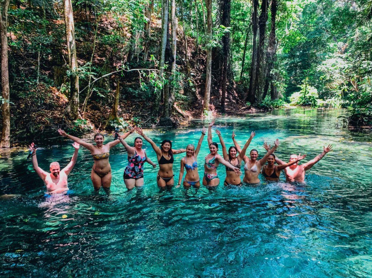 A group shot while in the clear bright blue water at the waterfall in Mojo Island, Indonesia 