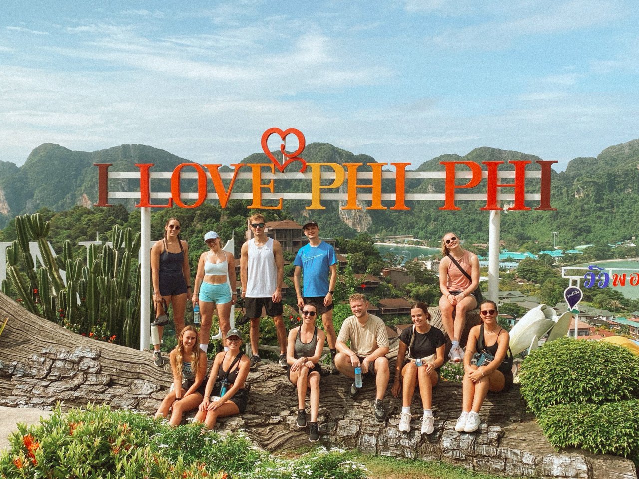 Group of backpackers at the Phi Phi viewpoint in the sun.